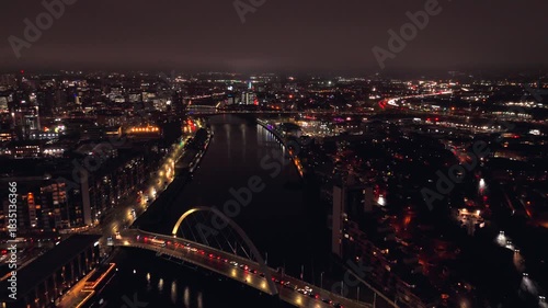 Glasgow Scotland: 26th Nov 2025: The River Clyde in Glasgow at night. Clyde Arc bridge cross over the water, and city lights reflect on the river. Cars move along the streets