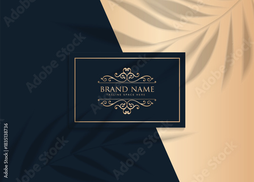A sophisticated logo featuring ornate scrollwork and the words 'BRAND NAME' centered on a dark blue and golden background with leaf shadows.