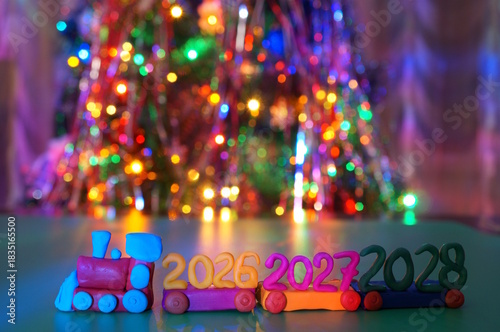 A toy train made of plasticine with a date of 2026, 2027 and 2028. A festive event.