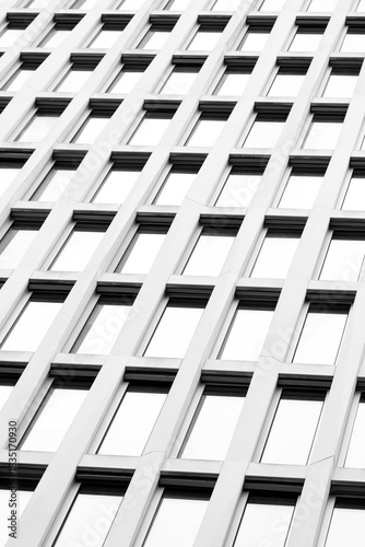 Architecture facade built on pattern and repetition supported by geometry, glass, reflection, structure, symmetry and abstract pattern to present a minimal balanced commercial visual frame