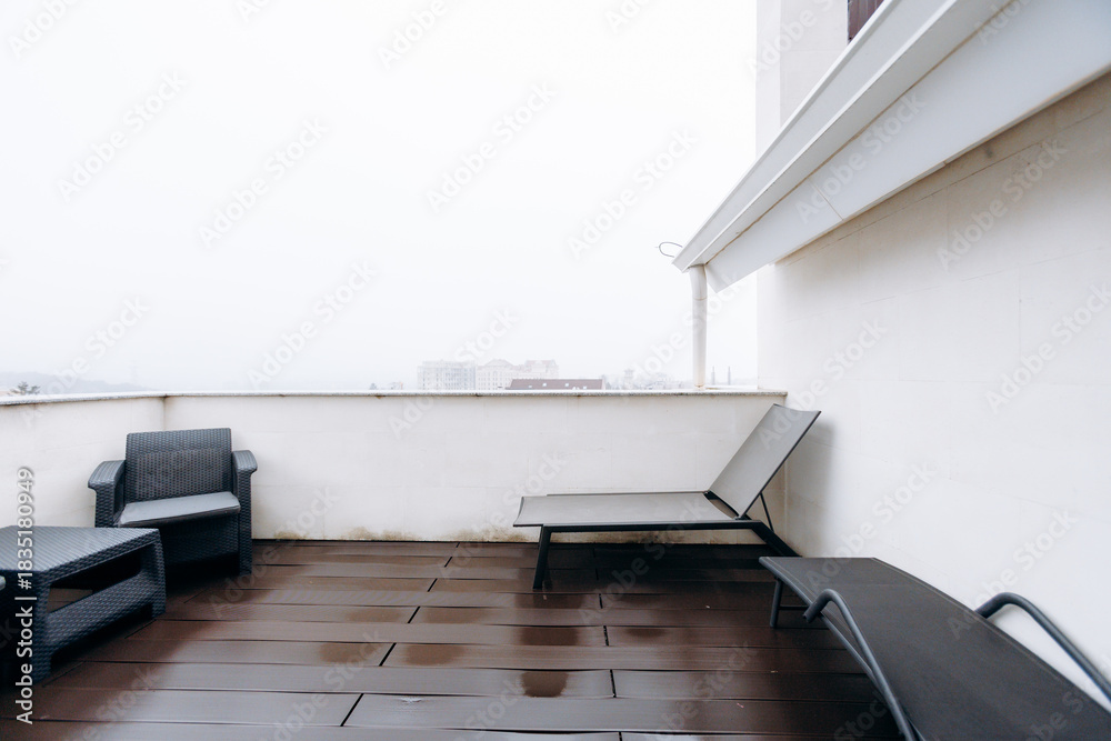 Naklejka premium Misty deck area featuring contemporary seating and reflective mood