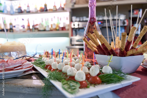 Foto inviting finger foods arranged on a bar with salame, mozzarella, Sala and tomato