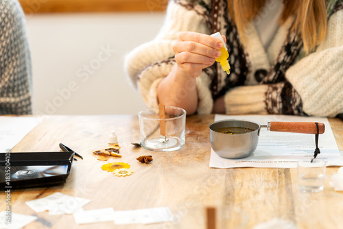 Woman creating natural aromatic soy candles in workshop