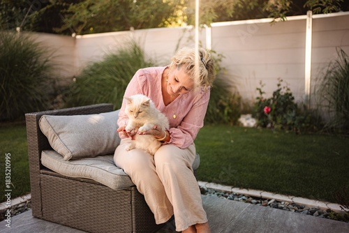 Woman petting cat in garden relaxing outdoors
