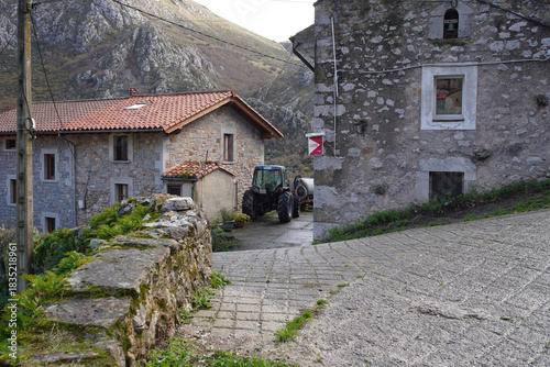 Limestone Peaks Nestle Over Red-Blue Valley, Cantabria - Old house features in rural landscape with weathered stone buildings, sparse vegetation, and overcast sky.