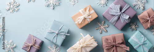 Pastel presents and snowflakes on a light blue background flat lay view