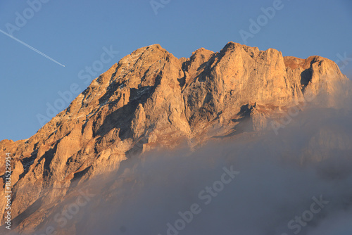 Blickfang über Grindelwald, der Mättenberg im Abdendlicht ragt aus dem Hochnebel
