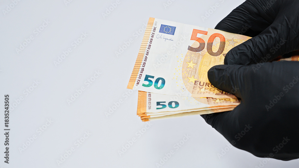 Φωτογραφία Close-up of hands in black gloves counting euro banknotes, symbolizing crime, corruption, money laundering, illegal finance, and underworld economic activities