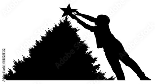Silhouette of a person placing a star on top of a Christmas tree.
