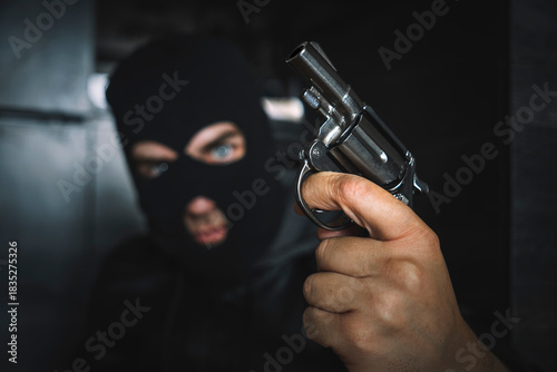 Fényképezés Terrorist hooded in balaclava, holding gun in hand