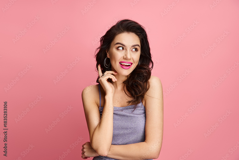 Fototapeta premium Joyful young woman expressing her playful spirit against a vibrant pink backdrop