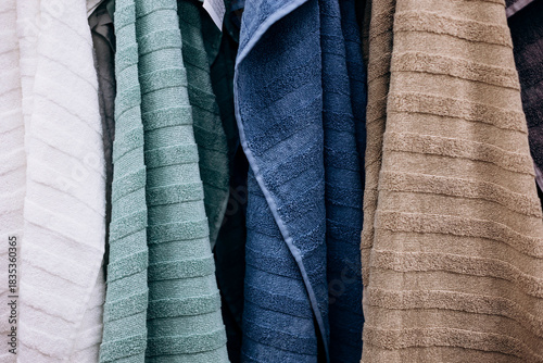 Hanging bathroom towels in assorted colors, close-up.