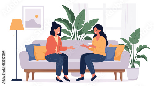 Two women sit on a couch and talk while holding drinks in a cozy room with plants.