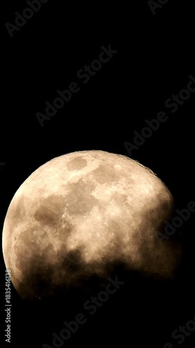 Close-Up of the Full Moon with Visible Lunar Surface and Craters, Partially Obscured by Thin Clouds in a Vertical Frame.