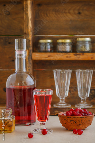 Cranberry tincture (liqueur). Homemade alcoholic drink with berries and spices with honey