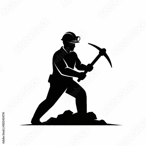 Silhouette of a determined miner working with a pickaxe in the mine.
