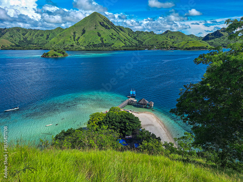 Tropical Paradise Lagoon with Overwater Pier and Green Hills, Komodo National Park, Indonesia