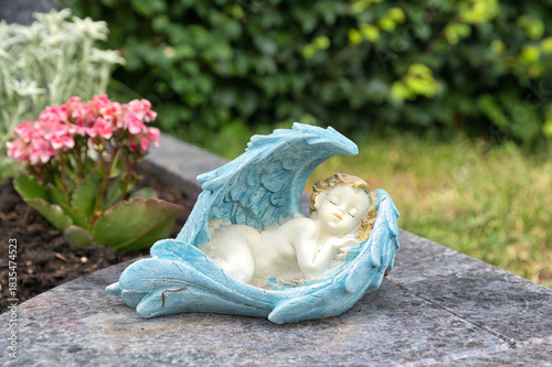 ein kleiner Engel schläft zwischen seinen Flügeln auf dem Katholischen Friedhof in Kempten - Allgäu