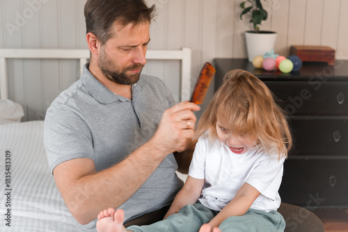 Man brushing daughters hair. Daddy combing girl's hair at home. Responsible good dad braiding his child girl's hair. Handsome father grooming his little one. Morning routine concept. Family life