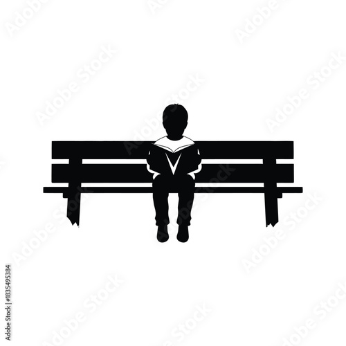 Silhouette of a young boy wearing a sailor collar shirt reading a book while sitting on a park bench