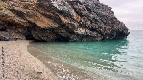 Coastal serenity: waves gently embrace secluded rocky beach