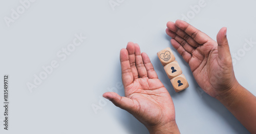 Fotografija Hands protect wood cube with empathy leadership icon