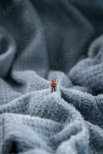 A mountaineer figurine on a fluffy fleece fabric that looks like a snow-covered mountain surface