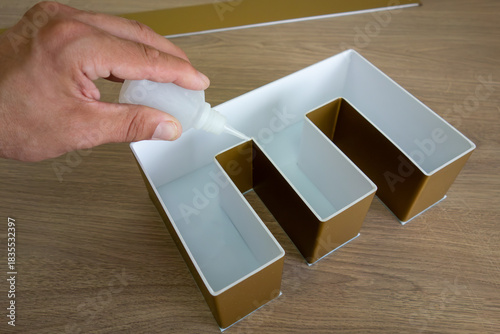 The process of assembling outdoor advertising in production.Gluing large-volume letters made of high-quality plastic for an advertising sign.