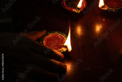 Hand grabs the colorful oil lamp to prepare for Karthigai deepam