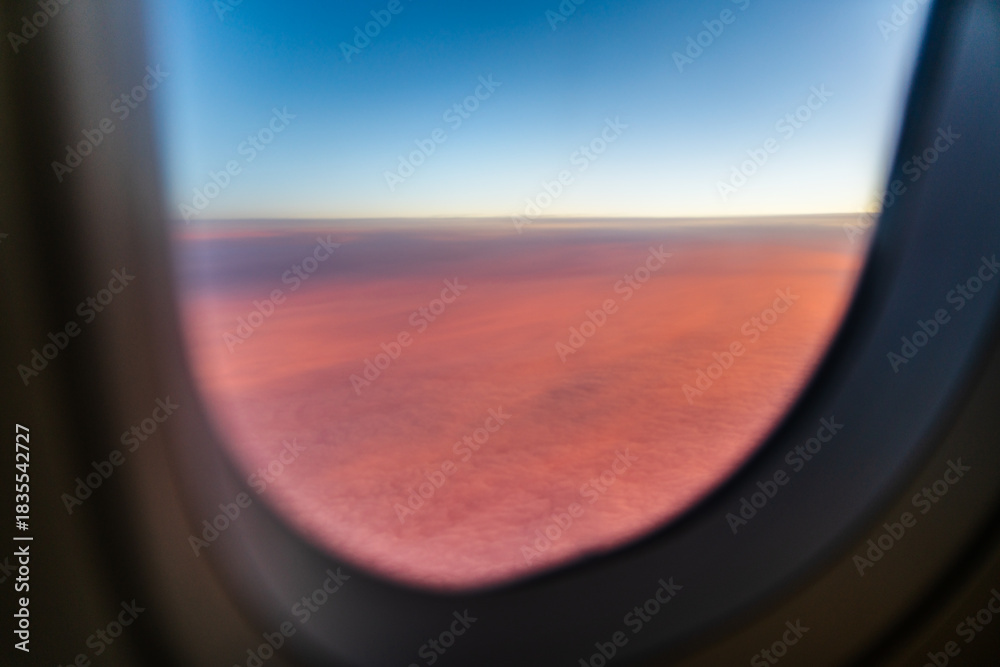 Fototapeta premium View from airplane's window above clouds during sunset