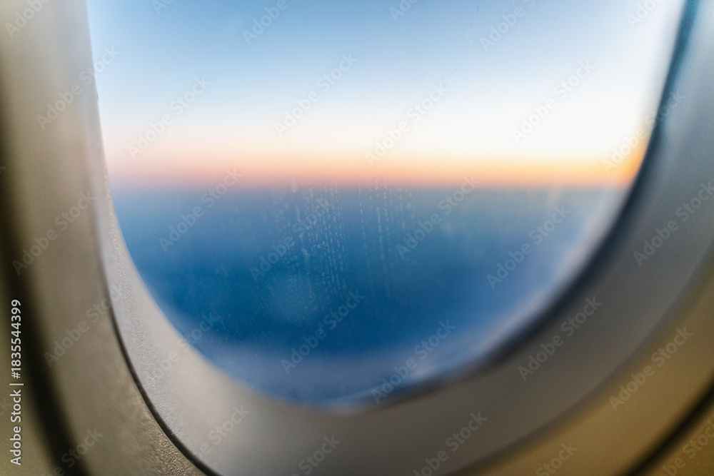 Fototapeta premium View from airplane's window above clouds during sunset