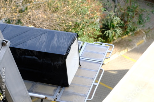 House moving with elevators. Lifting beds, paintings, refrigerators, coffee tables, and other packaged items. Movers loading items onto trucks. Tenants, homeowners. House rents. Housing prices.