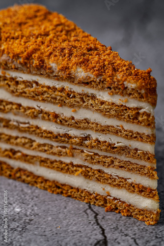 Wallpaper Mural Honey cake slice with layered cream filling on a cracked gray concrete background, close-up dessert photography Torontodigital.ca