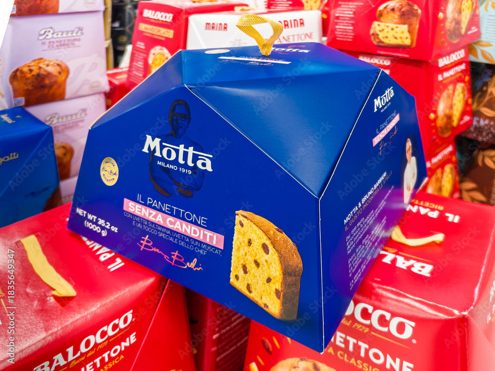 Fototapeta premium Italy - December 2, 2025: Motta panettone made according to chef Bruno Barbieri's recipe, packaged in a blue box and displayed alongside other brands of panettone for sale in supermarkets 