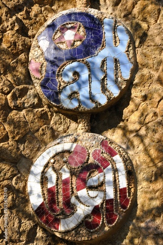 Colorful mosaic medallions at Park Güell in Barcelona, showcasing Gaudí’s signature trencadís style on the stone entrance wall.