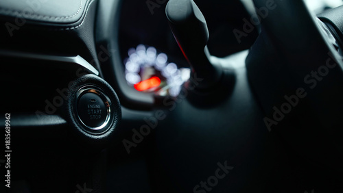 Close-up view of a modern car's ignition button and gear shift, showcasing sleek interior design elements and advanced technology features in an automotive environment
