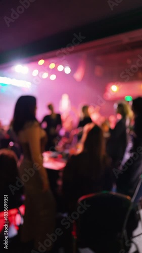 Energetic female dancer performs passionately amidst colorful lighting and lively crowd background