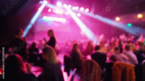 Upscale gala with guests at candlelit tables watching captivating live act under colorful lighting