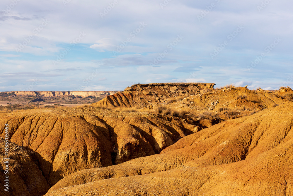 Naklejka premium Colors of the desert at sunset reveal stunning shapes and textures in the rugged landscape
