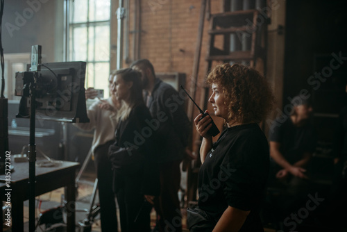 Director at work on the set. The director works with a group or with a playback while filming a movie, advertising, or a TV series. Shooting shift, equipment and group. Modern photography technique.