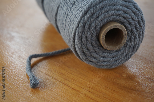 Close-up of a thick cotton macrame cord spool, textured fiber material, handmade craft supplies, slow living hobby, cozy DIY atmosphere