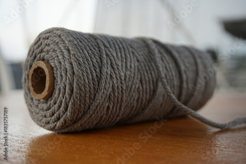 Close-up of a thick cotton macrame cord spool, textured fiber material, handmade craft supplies, slow living hobby, cozy DIY atmosphere