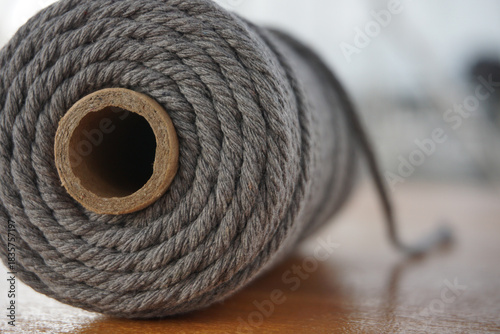 Close-up of a thick cotton macrame cord spool, textured fiber material, handmade craft supplies, slow living hobby, cozy DIY atmosphere