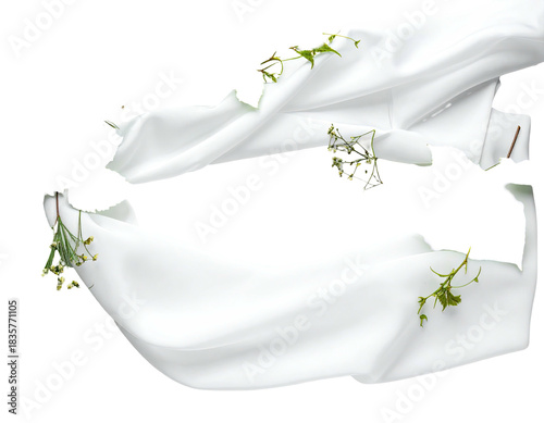 White fabric sections with greenery elements placed upon a black background