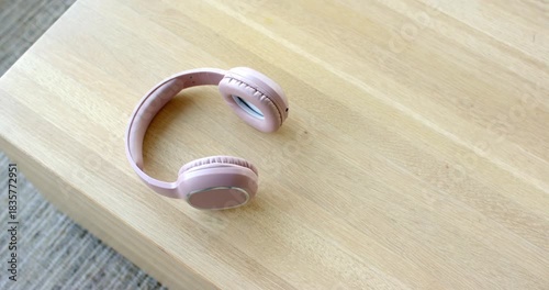 Camera is starting recording capturing overhead shot of pink wireless headset on table for display