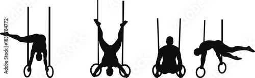 Four male gymnasts performing on rings in silhouette gymnastics