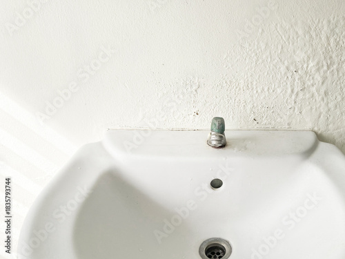 Broken Washbasin on Damped, Musty Old Painted Wall with Sunlight. Textured Exterior Toilet Wall in Room at Dhamma Retreat Center, Saraburi, Thailand. 25 OCT 2025. A.M.