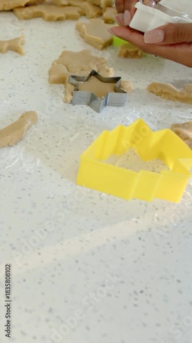 Vertical video: Pressing two hands with ejector, releasing star dough pieces on counter for baking