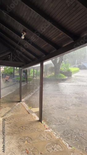 Heavy Tropical Rain Falling Under a Wooden Roof Canopy