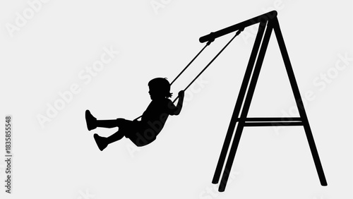 Silhouette of a child joyfully swinging on a playground swing set.
